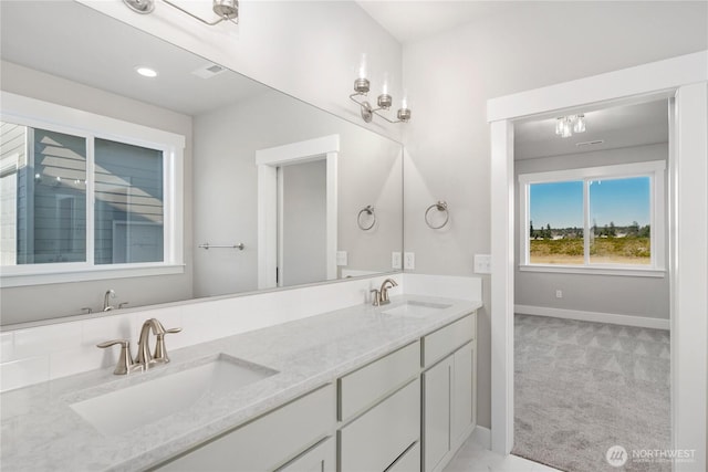 bathroom featuring a sink, baseboards, and double vanity