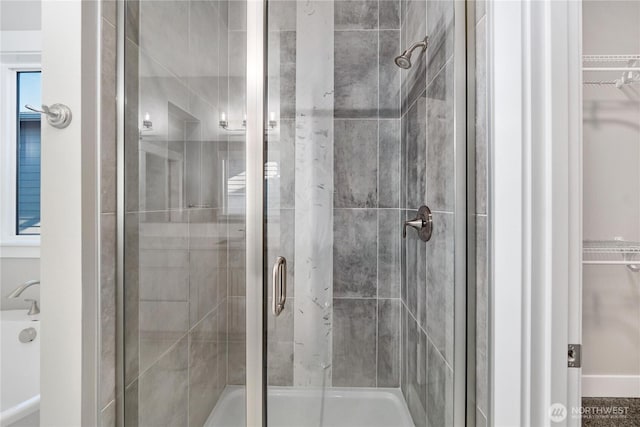 full bath featuring a walk in closet and a shower stall