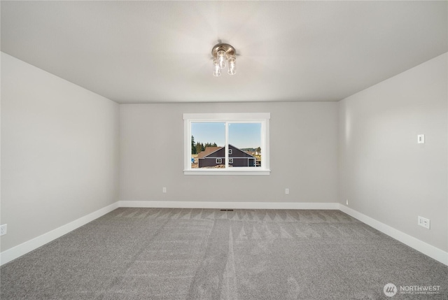 spare room with carpet floors, baseboards, and visible vents