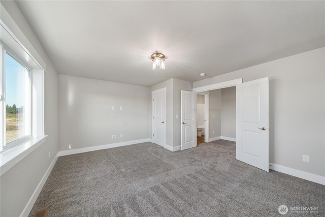 unfurnished bedroom with baseboards, visible vents, and carpet