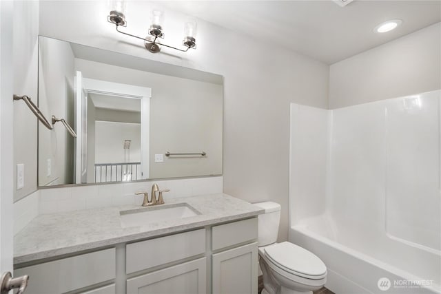 bathroom with vanity, bathing tub / shower combination, toilet, recessed lighting, and tasteful backsplash