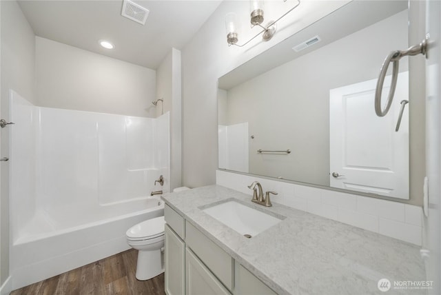 bathroom featuring shower / bathtub combination, toilet, wood finished floors, and visible vents