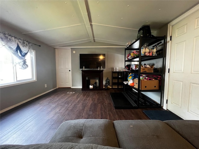 living area featuring baseboards, wood finished floors, and lofted ceiling