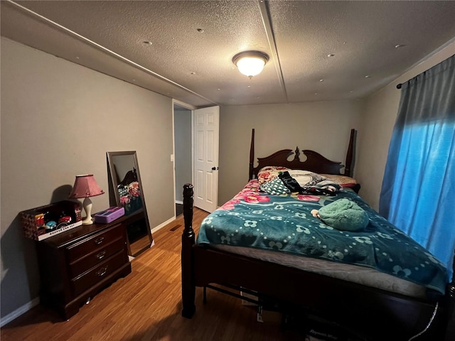 bedroom featuring a textured ceiling and wood finished floors