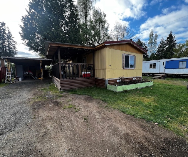 view of front of property featuring a carport, driveway, and a front lawn