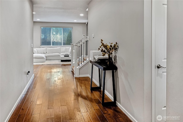 corridor with wood-type flooring and baseboards