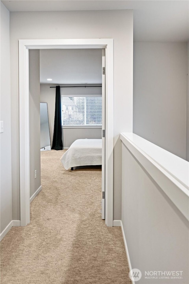 hallway featuring baseboards and carpet