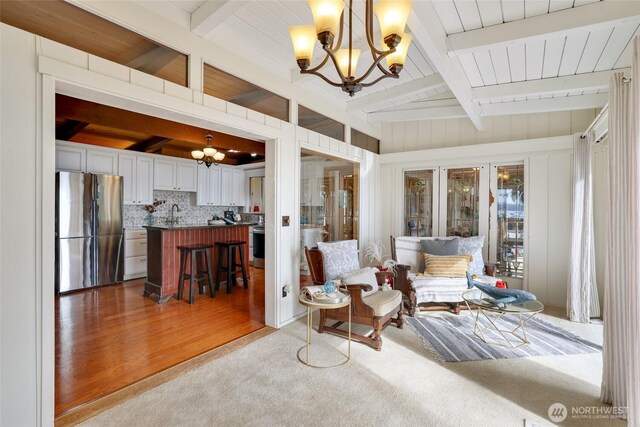110 SE Bay E Dr, Shelton, WA 98584 - living area featuring a chandelier, beamed ceiling, carpet flooring, and wood finished floors