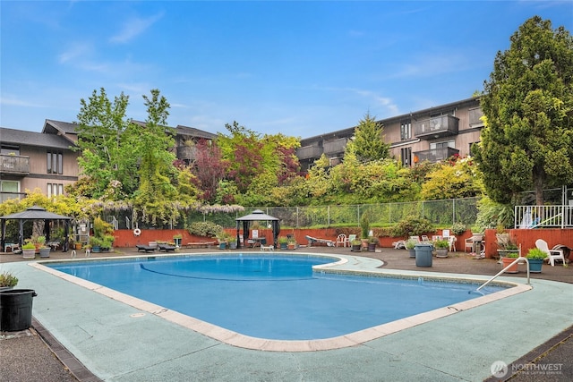 pool featuring fence, a patio, and a gazebo