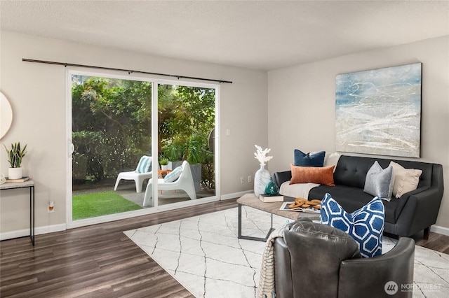 living area with baseboards and wood finished floors