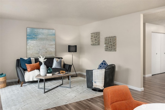 living area featuring baseboards and wood finished floors