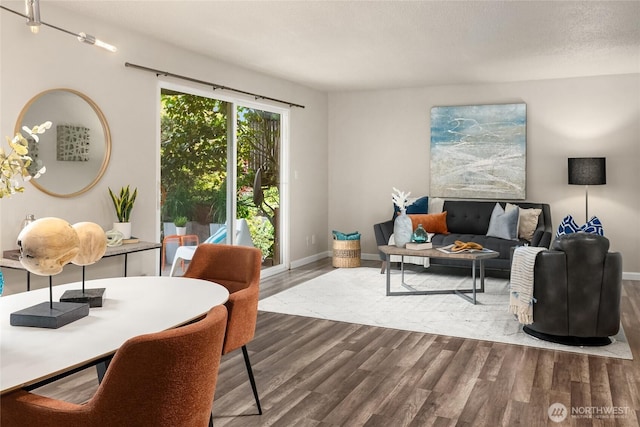 living area with baseboards and wood finished floors