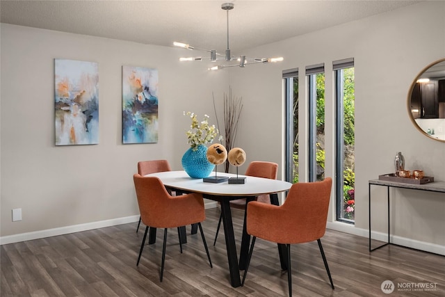 dining room with baseboards, a chandelier, and wood finished floors