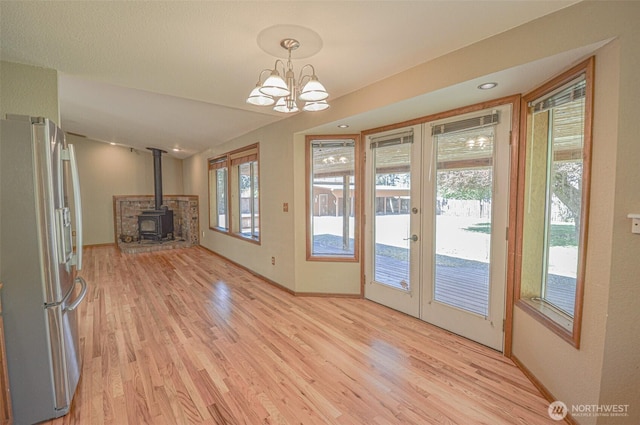 4310 Brookdale Rd E, Tacoma, WA 98446 - doorway to outside featuring french doors, a wood stove, light wood-style floors, a chandelier, and baseboards
