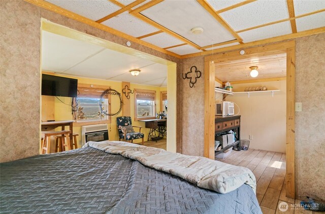 bedroom featuring heating unit and hardwood / wood-style floors