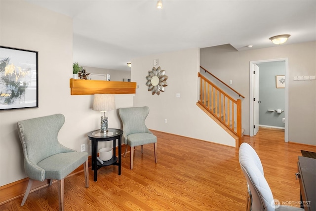 living area featuring stairs and light wood-style flooring