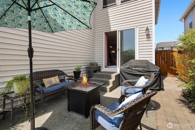 view of patio with an outdoor fire pit, fence, and grilling area