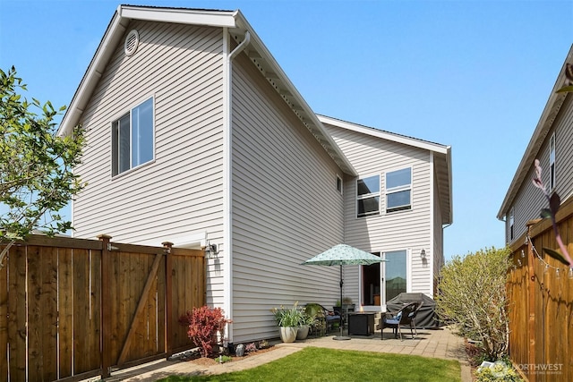 rear view of property with a patio and fence