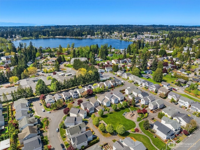 aerial view featuring a water view, a residential view, and a wooded view