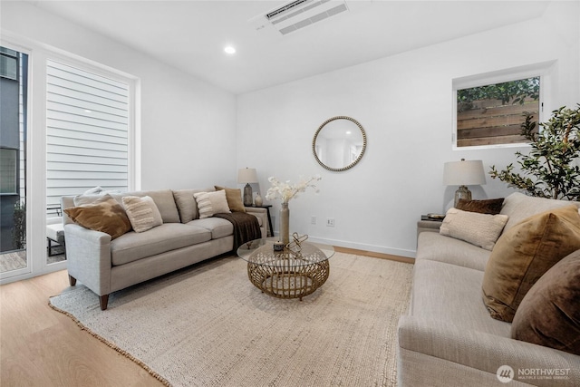 living room featuring visible vents, wood finished floors, baseboards, recessed lighting, and a wealth of natural light