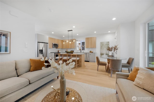 living room with recessed lighting and light wood-style flooring