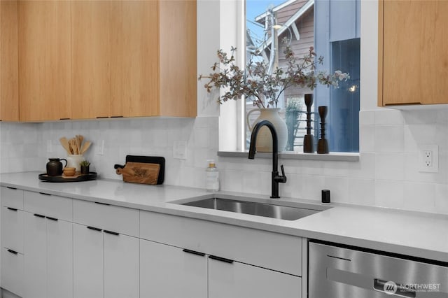 kitchen featuring a sink, modern cabinets, tasteful backsplash, and dishwasher