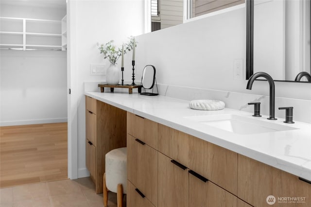 bathroom with vanity, baseboards, and tile patterned floors