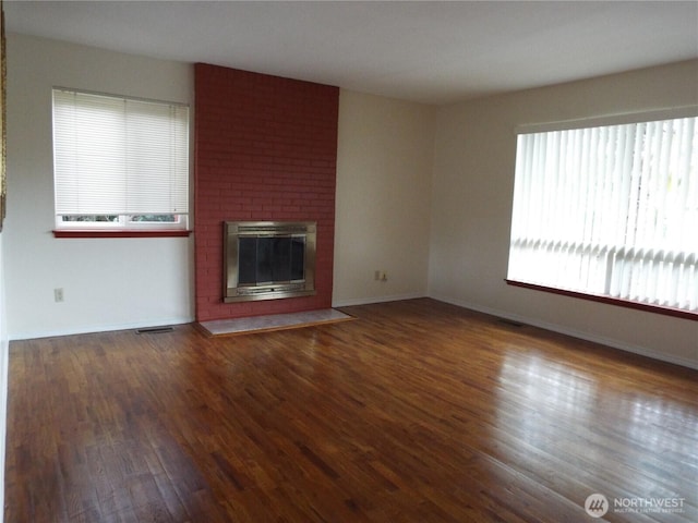 unfurnished living room featuring wood finished floors, a fireplace, and baseboards