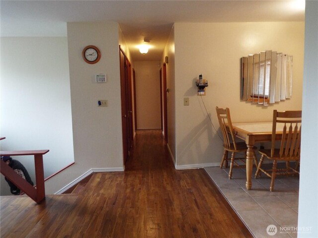 corridor with wood finished floors and baseboards