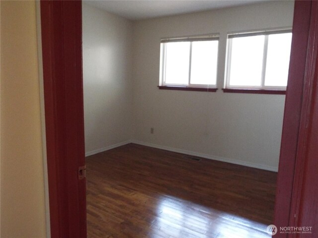 unfurnished room featuring wood finished floors and baseboards