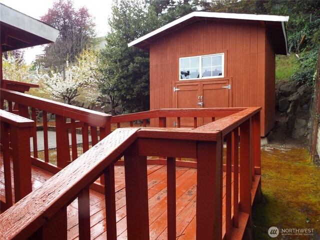 wooden terrace with a storage shed and an outbuilding
