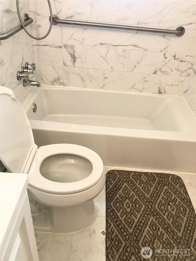 full bath with toilet, marble look tile flooring, and shower / washtub combination