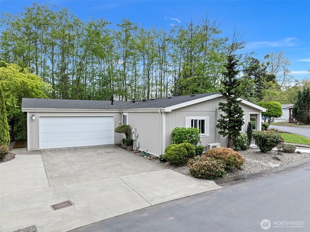 view of side of home featuring a garage and concrete driveway