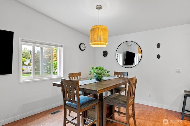dining space with visible vents, baseboards, and light wood finished floors