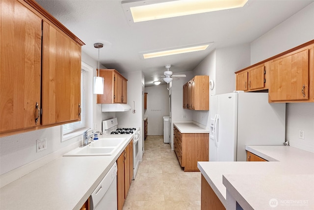 kitchen featuring white appliances, light countertops, separate washer and dryer, a sink, and hanging light fixtures