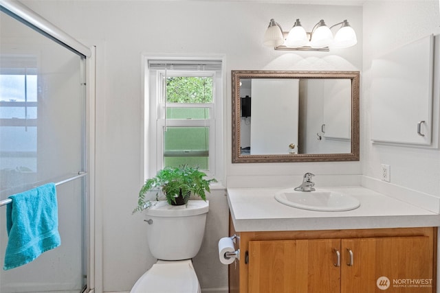 bathroom featuring an enclosed shower, vanity, and toilet