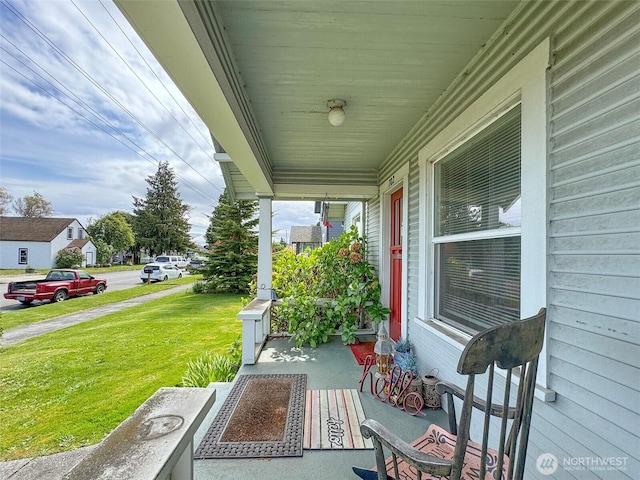 covered porch with a yard