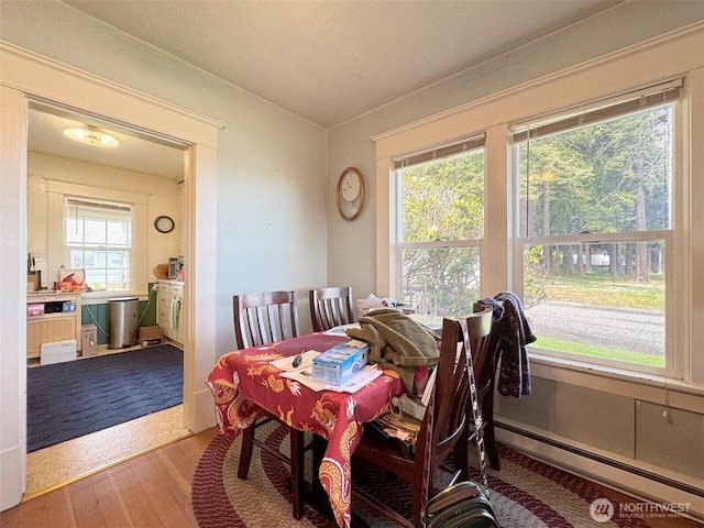 dining room featuring a baseboard radiator and wood finished floors