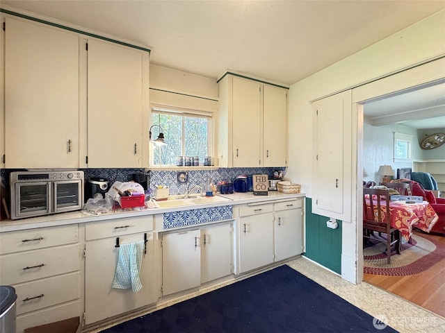 kitchen with light countertops, a sink, healthy amount of natural light, and backsplash