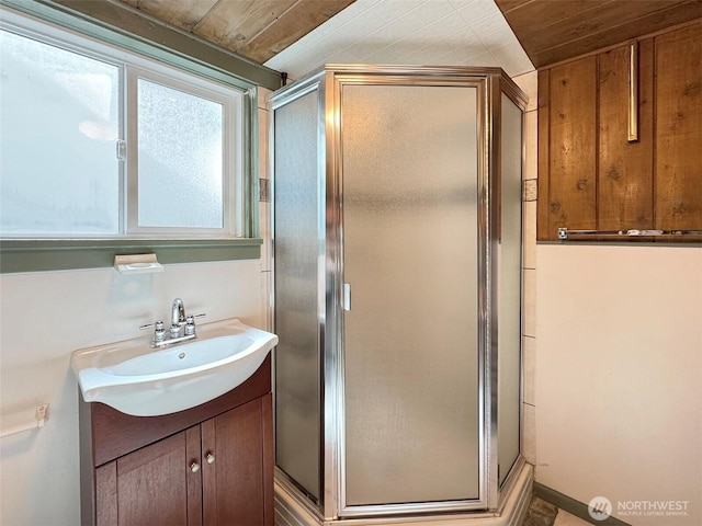 full bathroom featuring a shower stall, vanity, and wood ceiling