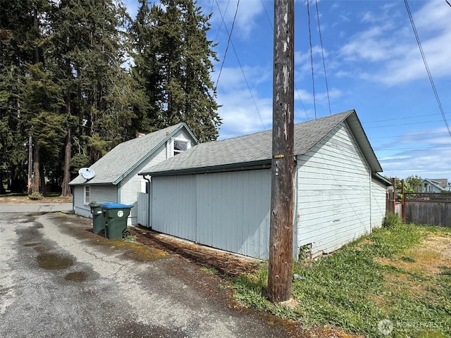 view of side of property with roof with shingles