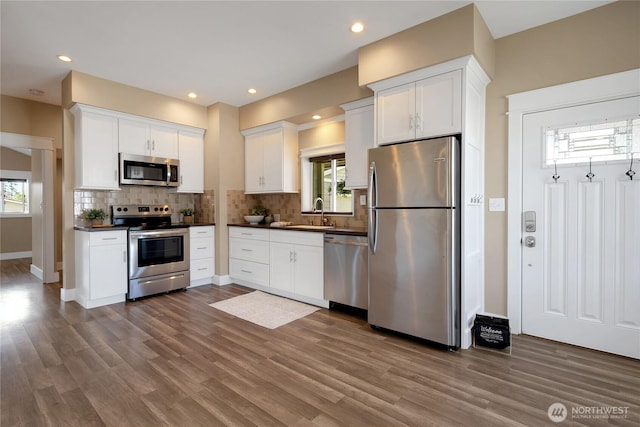 kitchen featuring dark countertops, stainless steel appliances, and dark wood-style floors