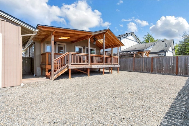 rear view of property with fence, a ceiling fan, and a wooden deck