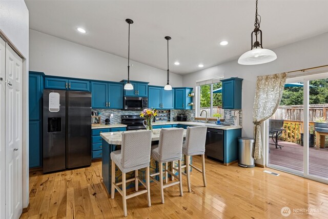 kitchen with light countertops, appliances with stainless steel finishes, open shelves, and blue cabinetry
