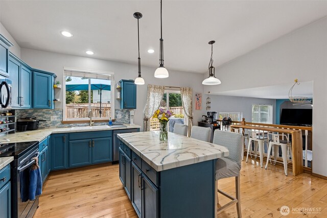 kitchen with black / electric stove, blue cabinetry, open shelves, a sink, and recessed lighting
