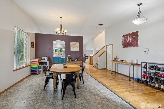 dining room featuring stairway, a chandelier, a wealth of natural light, and lofted ceiling