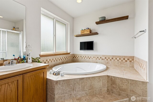 bathroom featuring vanity, a stall shower, and a bath