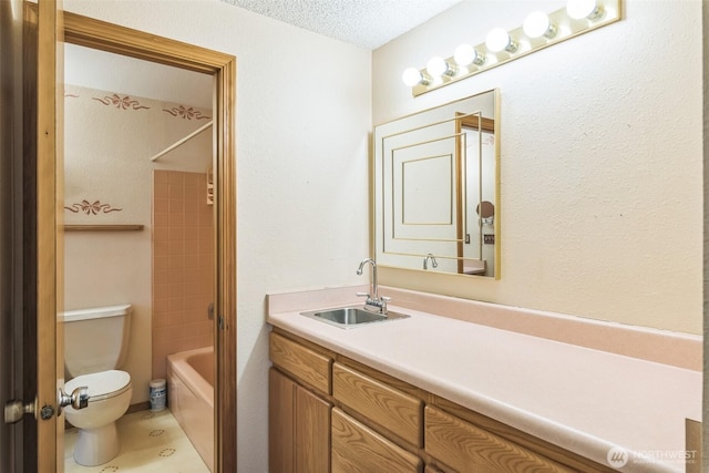 full bathroom with vanity, a textured ceiling, toilet, and shower / washtub combination