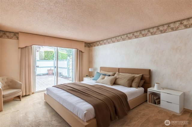 bedroom with access to outside, light carpet, and a textured ceiling