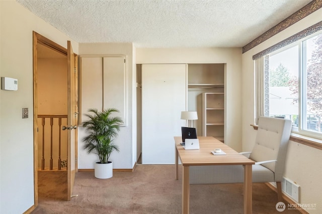 carpeted office featuring baseboards, a textured ceiling, and visible vents